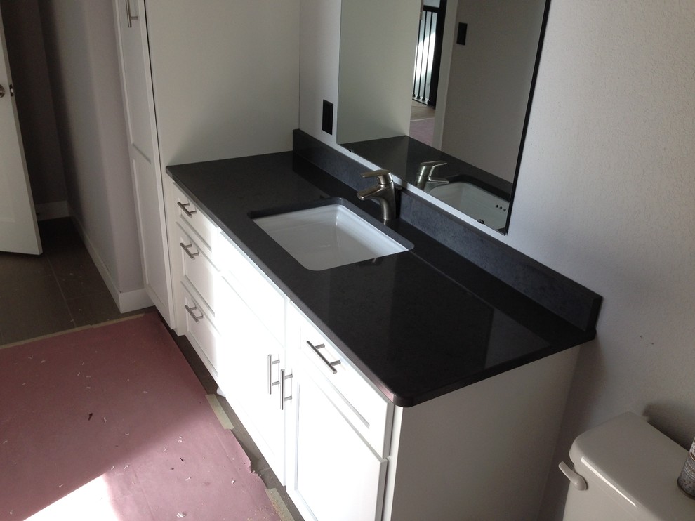 Foto di una stanza da bagno design di medie dimensioni con lavabo sottopiano, ante con riquadro incassato, ante bianche e top in quarzo composito