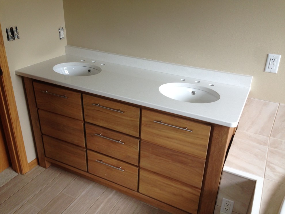 Immagine di una grande stanza da bagno minimal con lavabo sottopiano, ante lisce, ante in legno scuro e top in quarzo composito