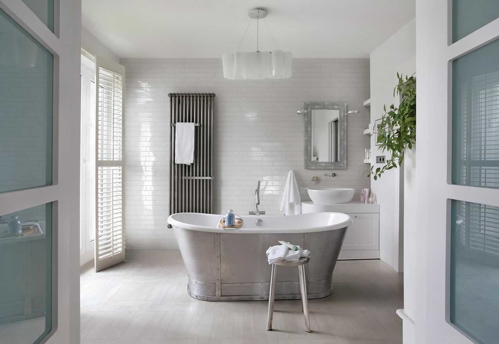Пример оригинального дизайна: главная ванная комната в стиле неоклассика (современная классика) с белыми фасадами, отдельно стоящей ванной, плиткой кабанчик, белыми стенами, настольной раковиной, фасадами в стиле шейкер и бежевым полом