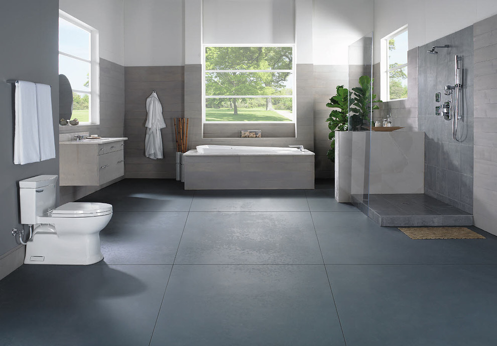 Inredning av ett modernt stort en-suite badrum, med ett platsbyggt badkar, en öppen dusch, en toalettstol med hel cisternkåpa, ett integrerad handfat, släta luckor, beige skåp, grå kakel, cementkakel, grå väggar, betonggolv, bänkskiva i akrylsten, grått golv och med dusch som är öppen