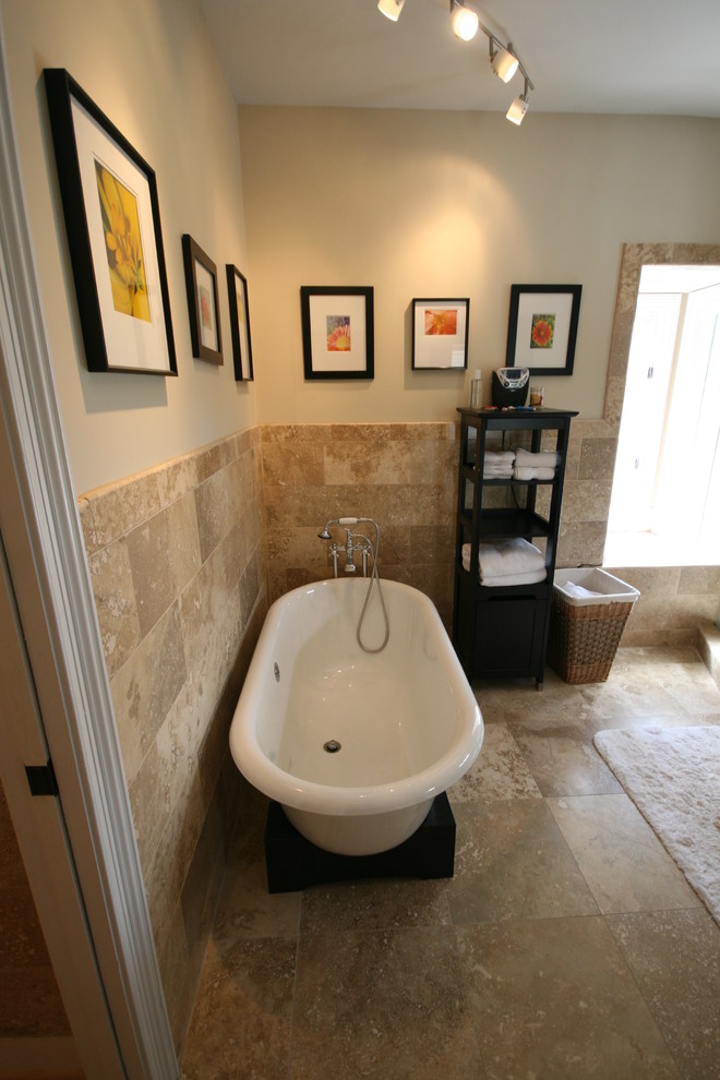 Inredning av ett modernt badrum, med ett fristående badkar, beige kakel och stenkakel
