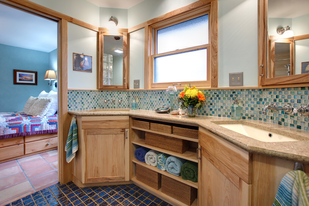 Идея дизайна: главная ванная комната среднего размера в стиле фьюжн с плоскими фасадами, светлыми деревянными фасадами, угловым душем, синей плиткой, стеклянной плиткой, синими стенами, полом из керамической плитки, врезной раковиной, столешницей из гранита, синим полом и бежевой столешницей