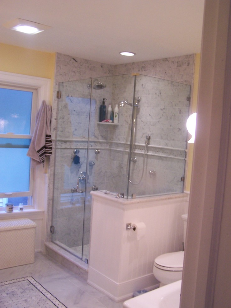 Example of a mid-sized ornate master gray tile and marble tile marble floor and white floor bathroom design in Philadelphia with a two-piece toilet, yellow walls, a pedestal sink, solid surface countertops and a hinged shower door