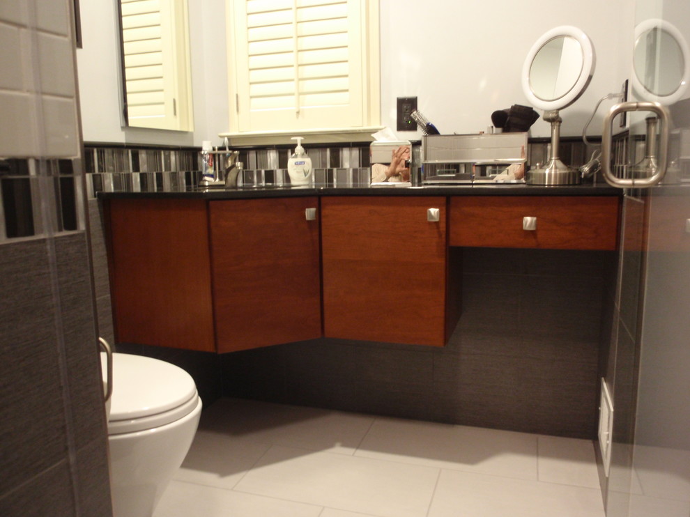 Exempel på ett litet modernt badrum med dusch, med ett undermonterad handfat, släta luckor, skåp i mellenmörkt trä, granitbänkskiva, en dusch i en alkov, en vägghängd toalettstol, flerfärgad kakel, keramikplattor, grå väggar och klinkergolv i porslin
