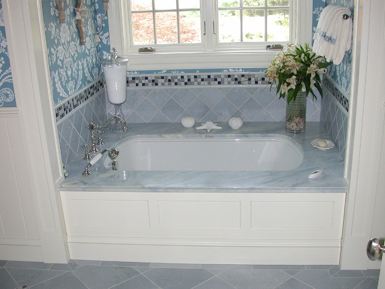 Aménagement d'une grande salle de bain principale classique avec une baignoire encastrée, un sol en marbre, un lavabo encastré, un plan de toilette en marbre et un sol blanc.