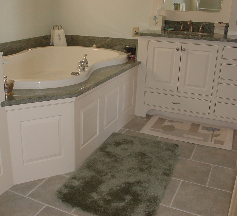 This is an example of a rustic bathroom in Portland Maine with a submerged sink, a built-in bath, raised-panel cabinets, white cabinets, granite worktops and green tiles.