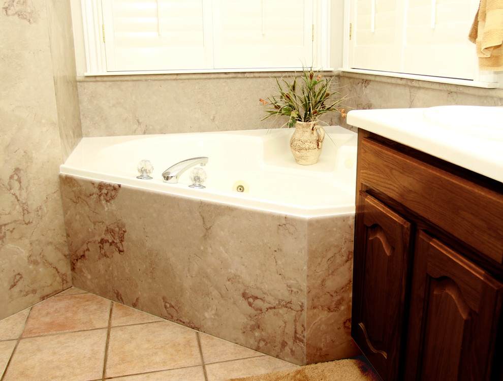Exempel på ett stort klassiskt en-suite badrum, med ett platsbyggt badkar, luckor med upphöjd panel, skåp i mörkt trä, brun kakel, stenhäll och bruna väggar