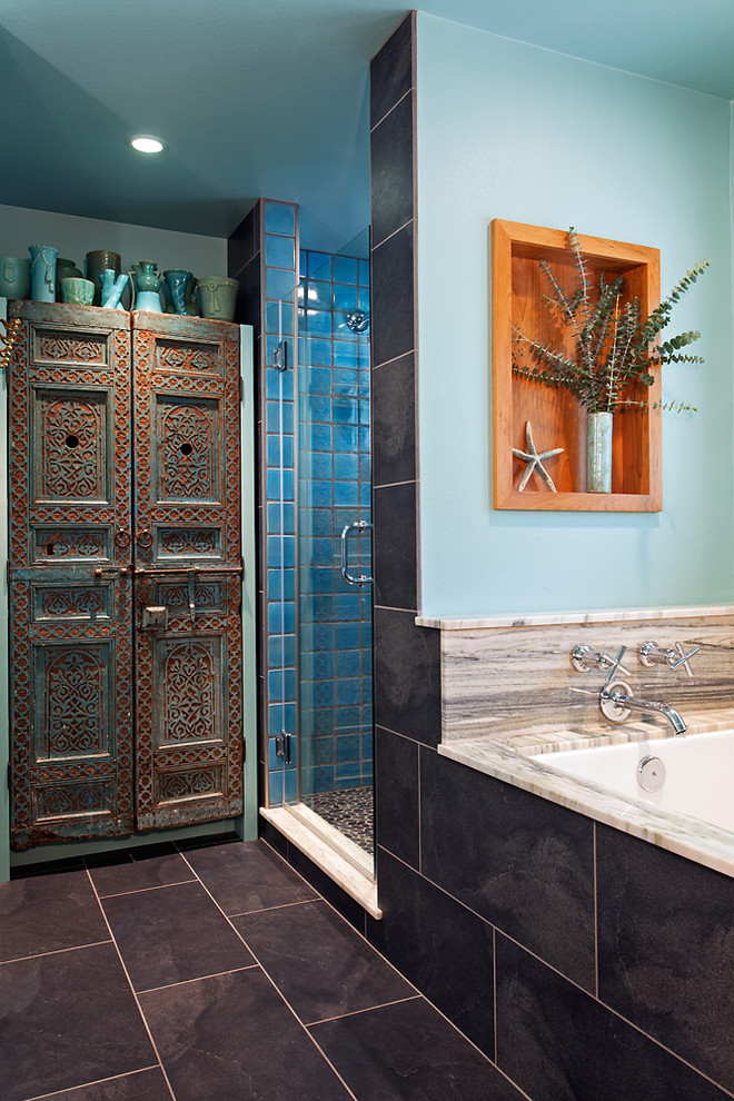 Medelhavsstil inredning av ett mellanstort en-suite badrum, med ett avlångt handfat, granitbänkskiva, en dusch i en alkov, svart kakel, porslinskakel, blå väggar och klinkergolv i keramik