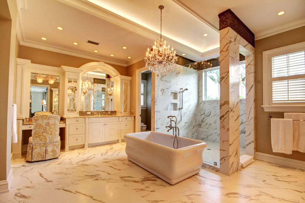 Свежая идея для дизайна: большая главная ванная комната в классическом стиле с фасадами с утопленной филенкой, белыми фасадами, отдельно стоящей ванной, душем в нише, унитазом-моноблоком, бежевой плиткой, белой плиткой, мраморной плиткой, бежевыми стенами, мраморным полом, врезной раковиной, столешницей из гранита, белым полом и душем с распашными дверями - отличное фото интерьера