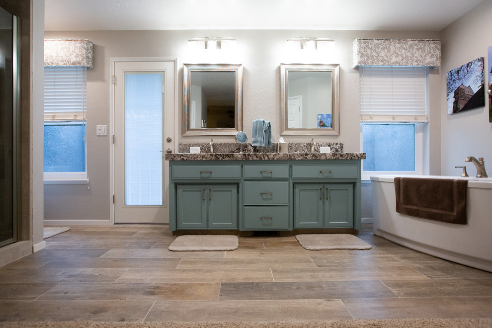 Источник вдохновения для домашнего уюта: большая главная ванная комната в современном стиле с синими фасадами, отдельно стоящей ванной, унитазом-моноблоком, белыми стенами, врезной раковиной, столешницей из гранита, коричневым полом, душем с распашными дверями и серой столешницей