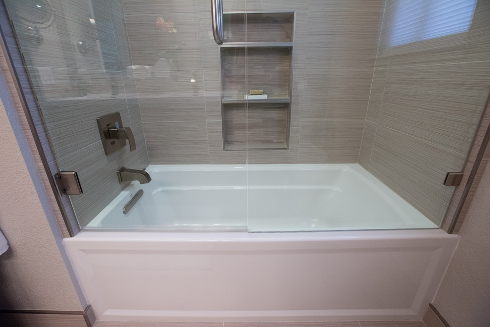 Foto di una stanza da bagno contemporanea con vasca ad alcova, vasca/doccia, pavimento in gres porcellanato, lavabo integrato, pavimento marrone e porta doccia a battente