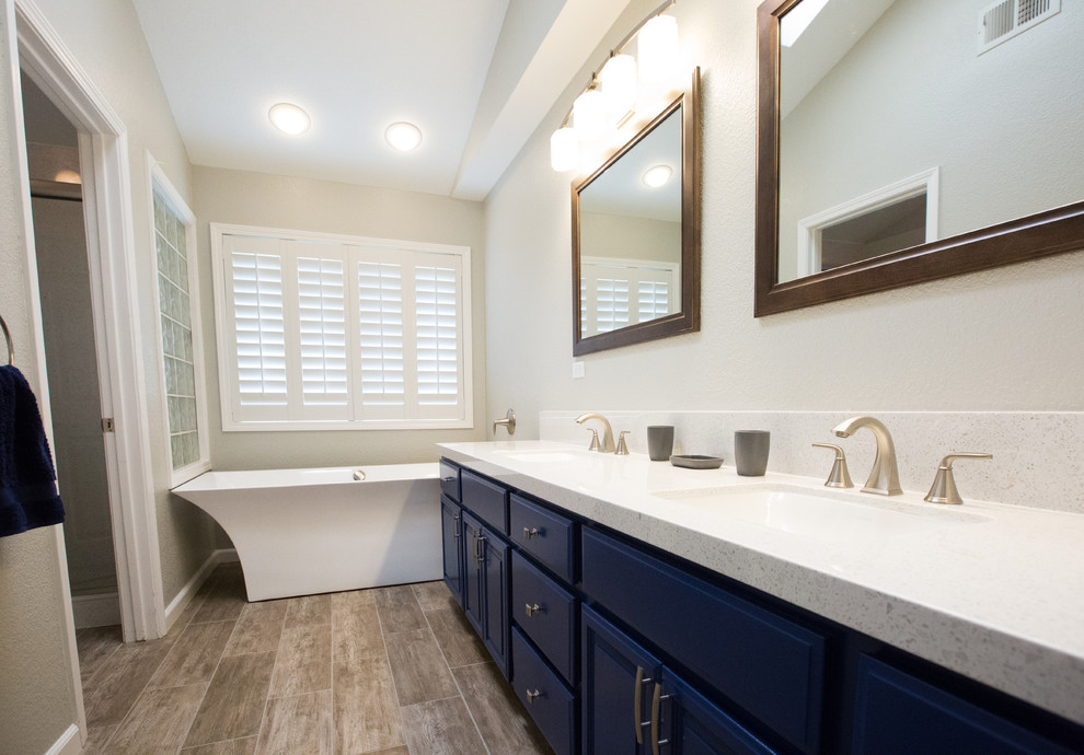 Immagine di una stanza da bagno minimalista con vasca freestanding, pavimento in gres porcellanato, top in marmo e porta doccia scorrevole