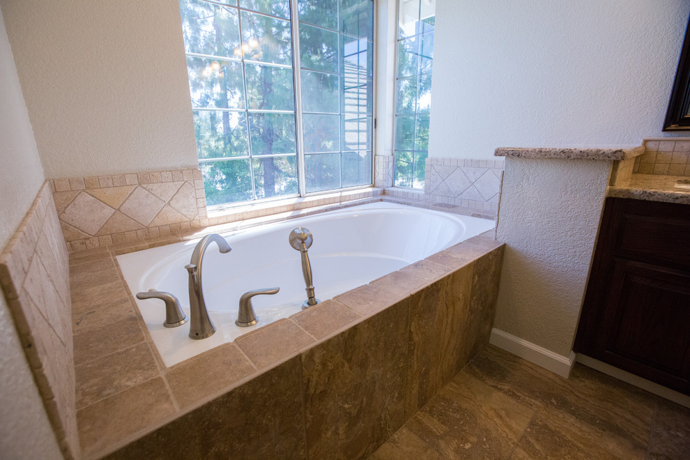 Photo of a large classic bathroom in Sacramento with dark wood cabinets, a submerged bath, beige tiles, porcelain flooring, a submerged sink, granite worktops and brown floors.