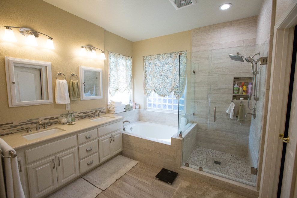 Shabby-Look Badezimmer mit weißen Schränken, Eckbadewanne, Eckdusche, Porzellan-Bodenfliesen, Unterbauwaschbecken und Falttür-Duschabtrennung in Sacramento
