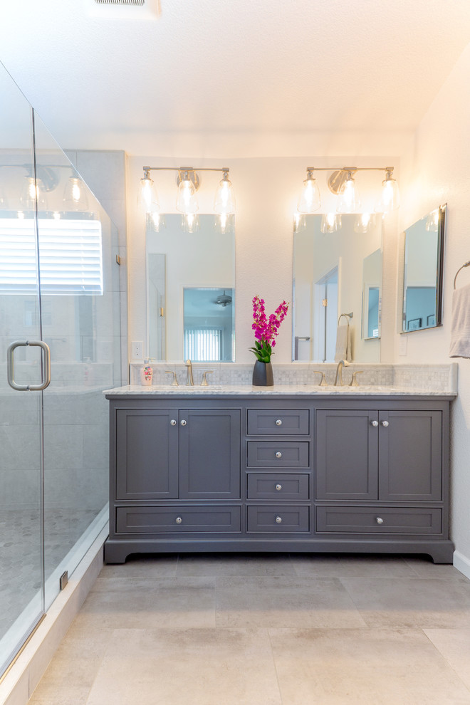 На фото: главная ванная комната в стиле модернизм с серыми фасадами, угловым душем, белыми стенами, врезной раковиной, мраморной столешницей, бежевым полом, душем с распашными дверями и серой столешницей с