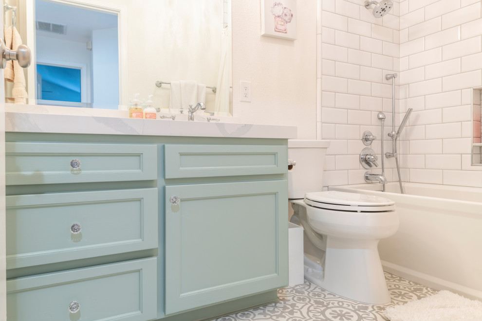 На фото: детская ванная комната в стиле модернизм с бирюзовыми фасадами, угловой ванной, душем над ванной, унитазом-моноблоком, бежевыми стенами, полом из цементной плитки, врезной раковиной, столешницей из искусственного кварца, разноцветным полом, шторкой для ванной, белой столешницей, тумбой под одну раковину и встроенной тумбой с
