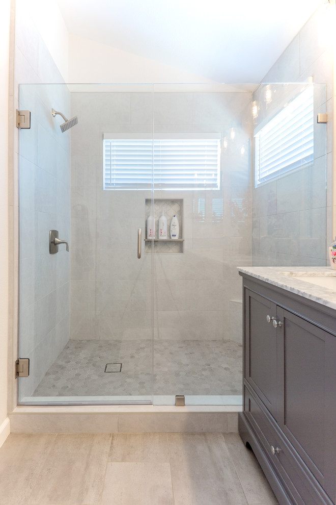 Свежая идея для дизайна: главная ванная комната в стиле модернизм с серыми фасадами, угловым душем, белыми стенами, врезной раковиной, мраморной столешницей, бежевым полом, душем с распашными дверями и серой столешницей - отличное фото интерьера