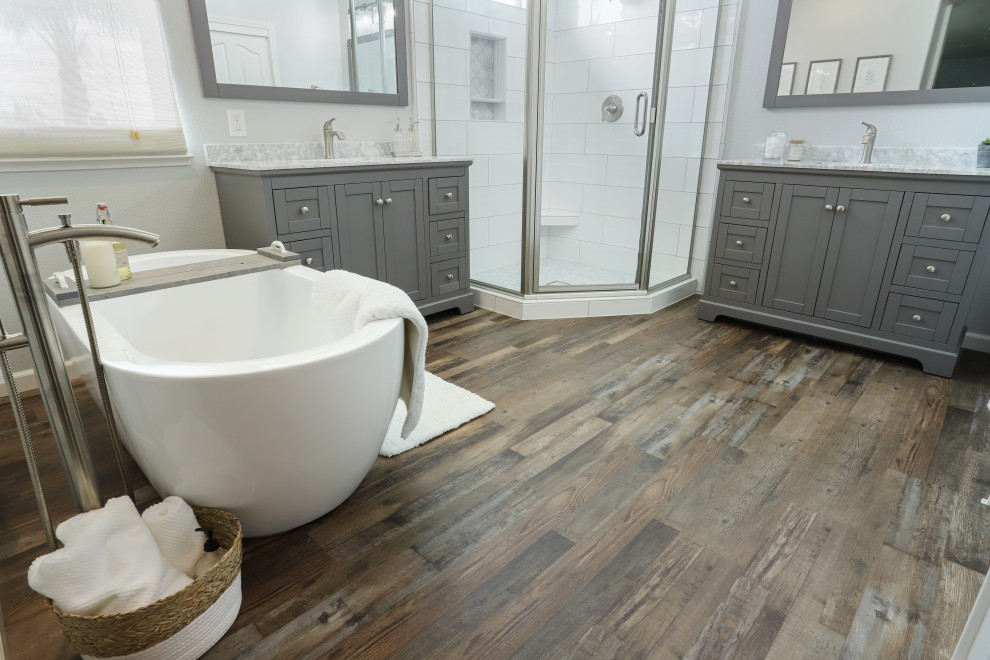 Idéer för att renovera ett funkis grå grått en-suite badrum, med grå skåp, ett fristående badkar, en hörndusch, grå väggar, laminatgolv, ett undermonterad handfat, marmorbänkskiva, brunt golv och dusch med gångjärnsdörr