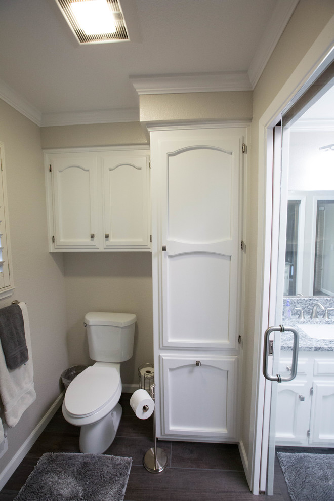 Idée de décoration pour une douche en alcôve minimaliste avec des portes de placard blanches, un sol en carrelage de porcelaine, un plan de toilette en granite et une cabine de douche à porte battante.