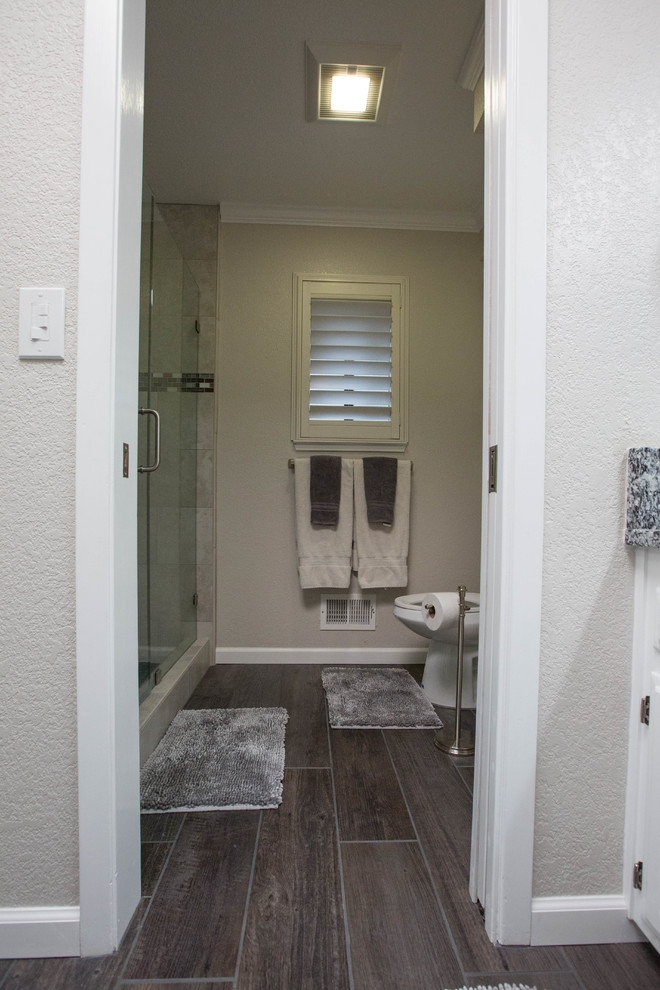 Modernes Badezimmer mit weißen Schränken, Duschnische, Porzellan-Bodenfliesen, Granit-Waschbecken/Waschtisch und Falttür-Duschabtrennung in Sacramento