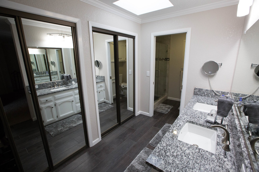 Modelo de cuarto de baño minimalista con puertas de armario blancas, ducha empotrada, suelo de baldosas de porcelana, encimera de granito y ducha con puerta con bisagras
