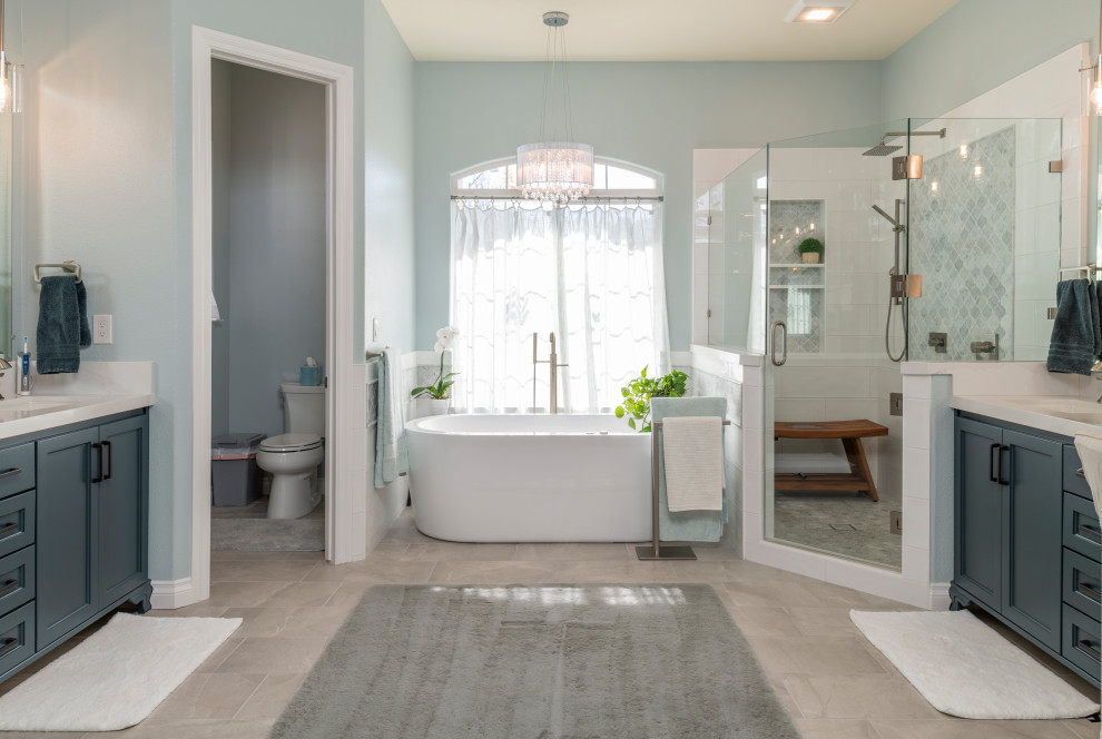 Источник вдохновения для домашнего уюта: главная ванная комната в стиле модернизм с синими фасадами, отдельно стоящей ванной, угловым душем, серыми стенами, полом из керамогранита, врезной раковиной, столешницей из искусственного кварца, коричневым полом, душем с распашными дверями, белой столешницей, нишей, тумбой под две раковины и встроенной тумбой