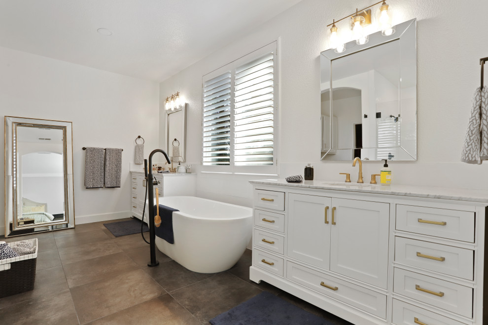Example of a minimalist master porcelain tile, brown floor and single-sink bathroom design in Sacramento with white cabinets, white walls, an undermount sink, marble countertops, a hinged shower door, gray countertops and a built-in vanity