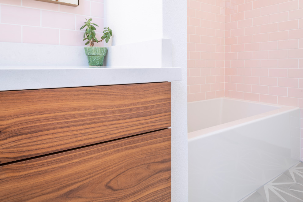 Inspiration for a classic bathroom in Sacramento with medium wood cabinets, a corner bath, a corner shower, pink tiles, ceramic tiles, white walls, porcelain flooring, a submerged sink, quartz worktops, multi-coloured floors and white worktops.