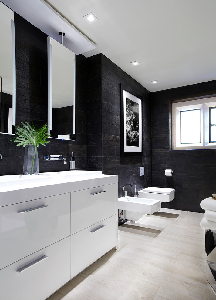 Inspiration pour une salle de bain minimaliste avec un placard à porte plane, des portes de placard blanches, un bidet, un mur noir, un sol en carrelage de porcelaine et un plan de toilette en surface solide.