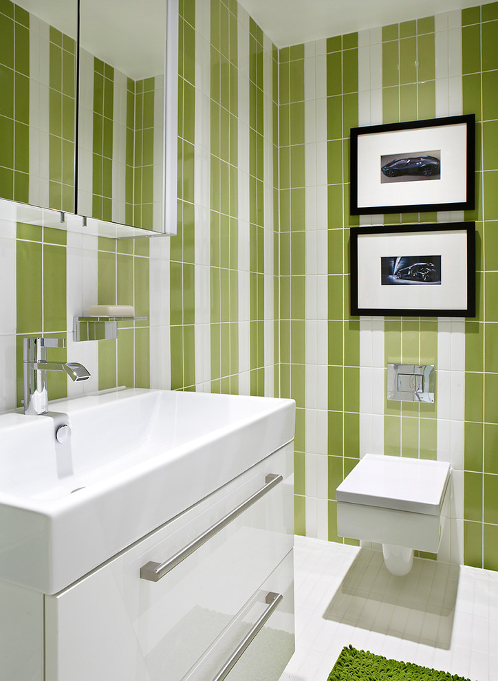 Photo of a medium sized contemporary bathroom in Los Angeles with flat-panel cabinets, white cabinets, a wall mounted toilet, multi-coloured walls and an integrated sink.