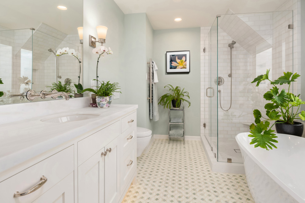 Idée de décoration pour une petite salle de bain tradition avec un placard à porte shaker, des portes de placard blanches, une baignoire indépendante, une douche d'angle, WC suspendus, un carrelage blanc, du carrelage en marbre, un mur vert, un sol en marbre, un lavabo encastré, un plan de toilette en marbre, un sol vert, une cabine de douche à porte battante, un plan de toilette blanc, meuble simple vasque et meuble-lavabo encastré.