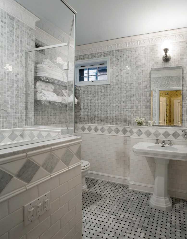 Idee per una stanza da bagno con doccia chic di medie dimensioni con piastrelle grigie, piastrelle in pietra, doccia ad angolo, lavabo a colonna e pavimento con piastrelle a mosaico