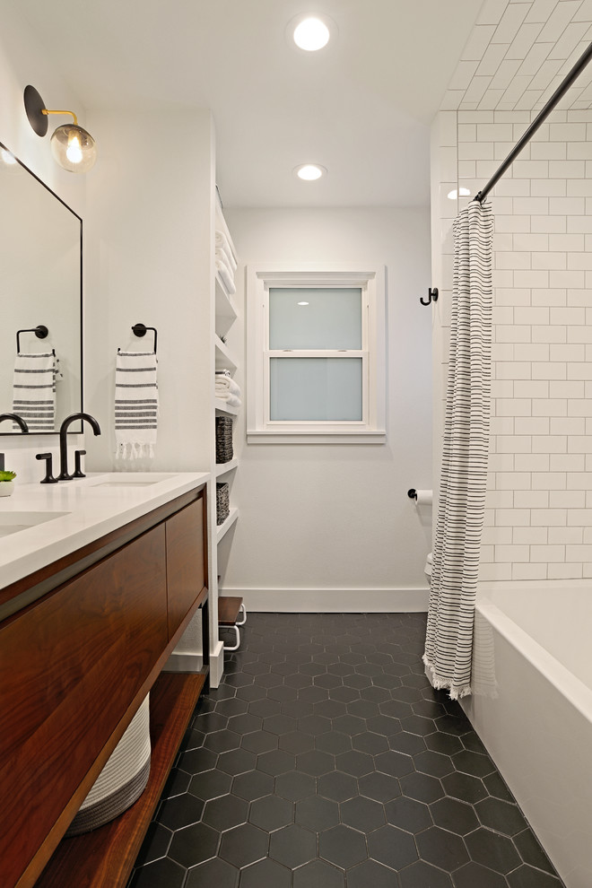 Foto på ett mellanstort retro vit badrum för barn, med släta luckor, skåp i mellenmörkt trä, ett badkar i en alkov, en dusch/badkar-kombination, en toalettstol med separat cisternkåpa, vit kakel, keramikplattor, vita väggar, klinkergolv i porslin, ett undermonterad handfat, bänkskiva i kvarts, svart golv och dusch med duschdraperi