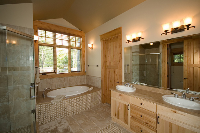 Klassisk inredning av ett stort badrum, med ett konsol handfat, skåp i ljust trä, ett badkar i en alkov, en hörndusch, beige kakel, vita väggar, keramikplattor och klinkergolv i keramik