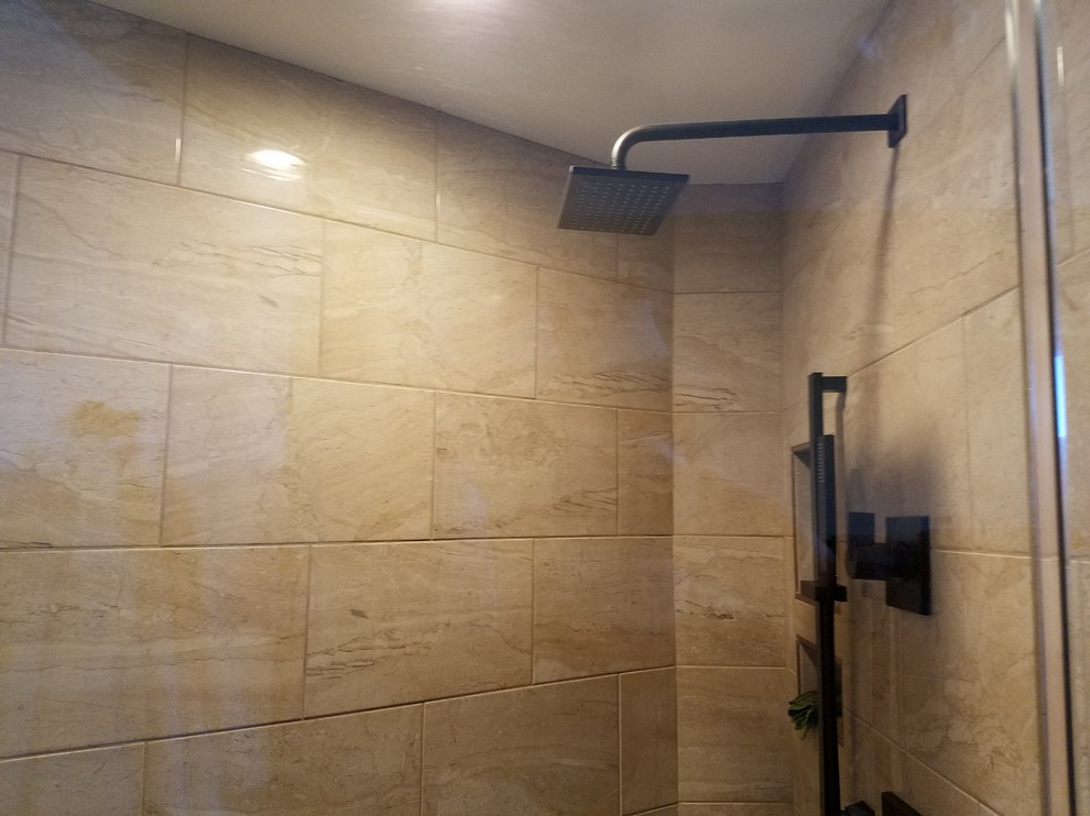 Klassisk inredning av ett en-suite badrum, med luckor med infälld panel, skåp i mellenmörkt trä, ett platsbyggt badkar, en dusch i en alkov, beige kakel, porslinskakel, vita väggar, ett fristående handfat, beiget golv och dusch med gångjärnsdörr
