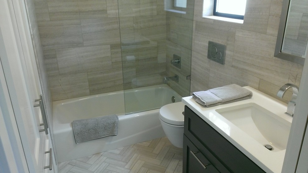 Inspiration for a transitional gray tile and stone tile alcove bathtub remodel in Austin with an undermount sink, recessed-panel cabinets, gray cabinets, marble countertops and a wall-mount toilet