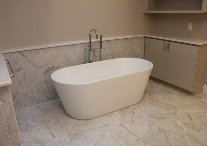 Idée de décoration pour une salle de bain principale design avec un plan de toilette en granite, une baignoire indépendante, un carrelage beige, des carreaux de porcelaine, un mur beige et un sol en carrelage de porcelaine.