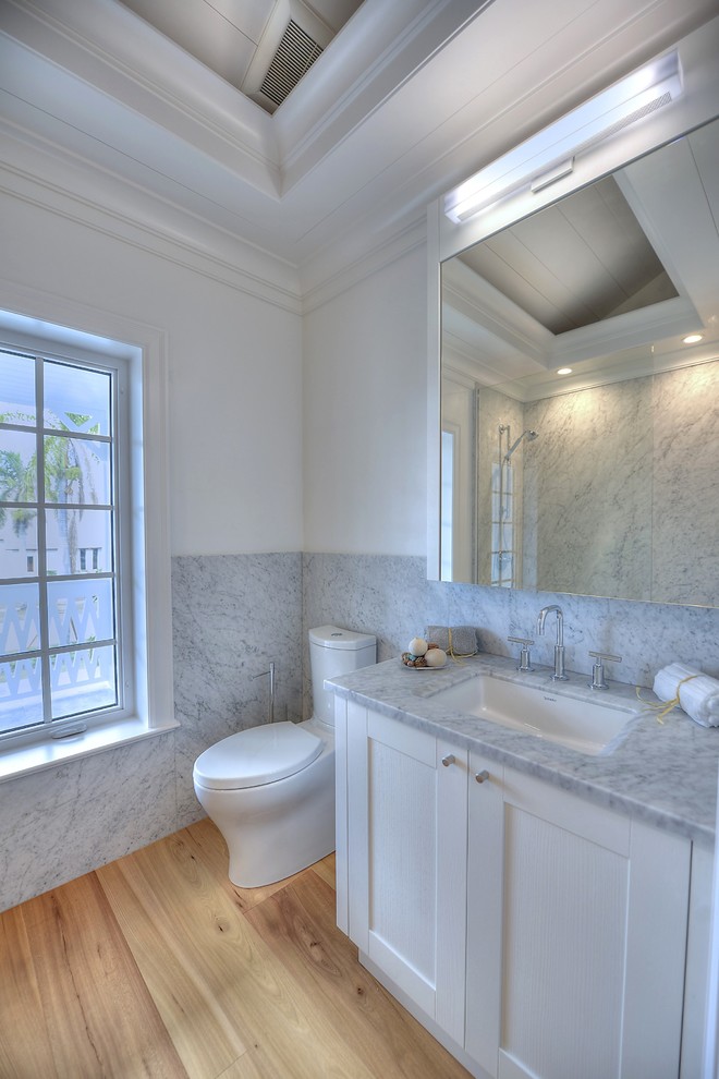 Ejemplo de cuarto de baño contemporáneo grande con puertas de armario blancas, encimera de mármol, lavabo bajoencimera, paredes blancas y suelo de madera en tonos medios