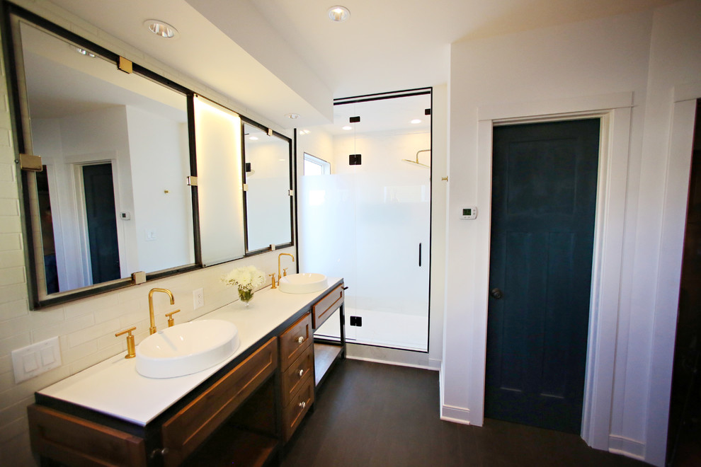 Large industrial ensuite bathroom in Minneapolis with a built-in sink, recessed-panel cabinets, medium wood cabinets, concrete worktops, a freestanding bath, an alcove shower, a one-piece toilet, white tiles, porcelain tiles, white walls and cork flooring.