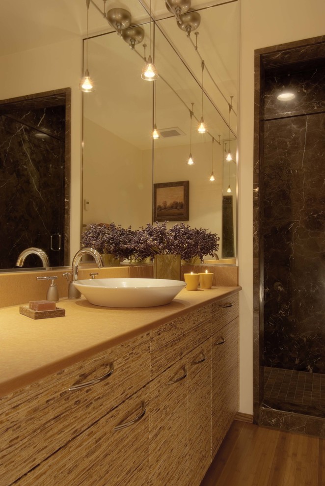 Exempel på ett litet modernt badrum med dusch, med släta luckor, skåp i ljust trä, en dusch i en alkov, beige väggar, bambugolv och ett fristående handfat