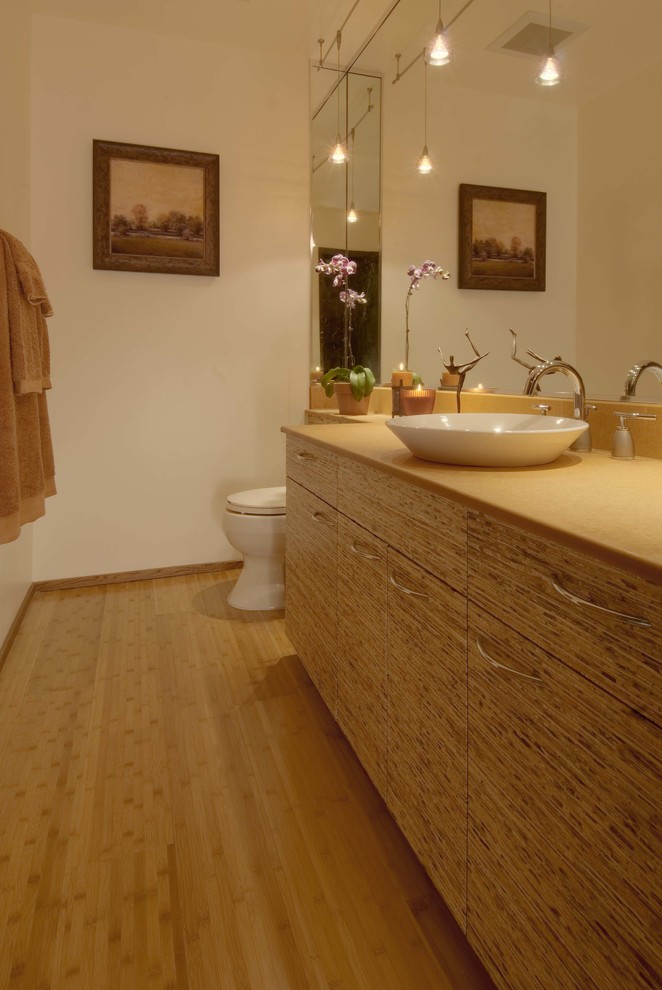 На фото: ванная комната среднего размера в современном стиле с плоскими фасадами, светлыми деревянными фасадами, унитазом-моноблоком, бежевыми стенами, полом из бамбука, душевой кабиной и настольной раковиной с