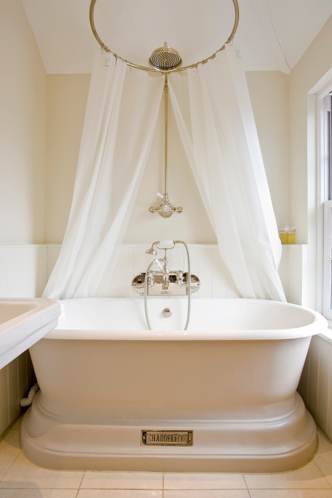 На фото: ванная комната в викторианском стиле с отдельно стоящей ванной и бежевыми стенами с