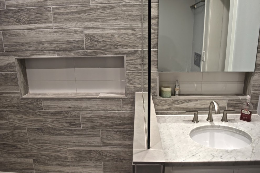 Inspiration for a medium sized classic bathroom in Atlanta with flat-panel cabinets, yellow cabinets, an alcove bath, a shower/bath combination, beige tiles, brown tiles, porcelain tiles, grey walls, porcelain flooring, a submerged sink and marble worktops.