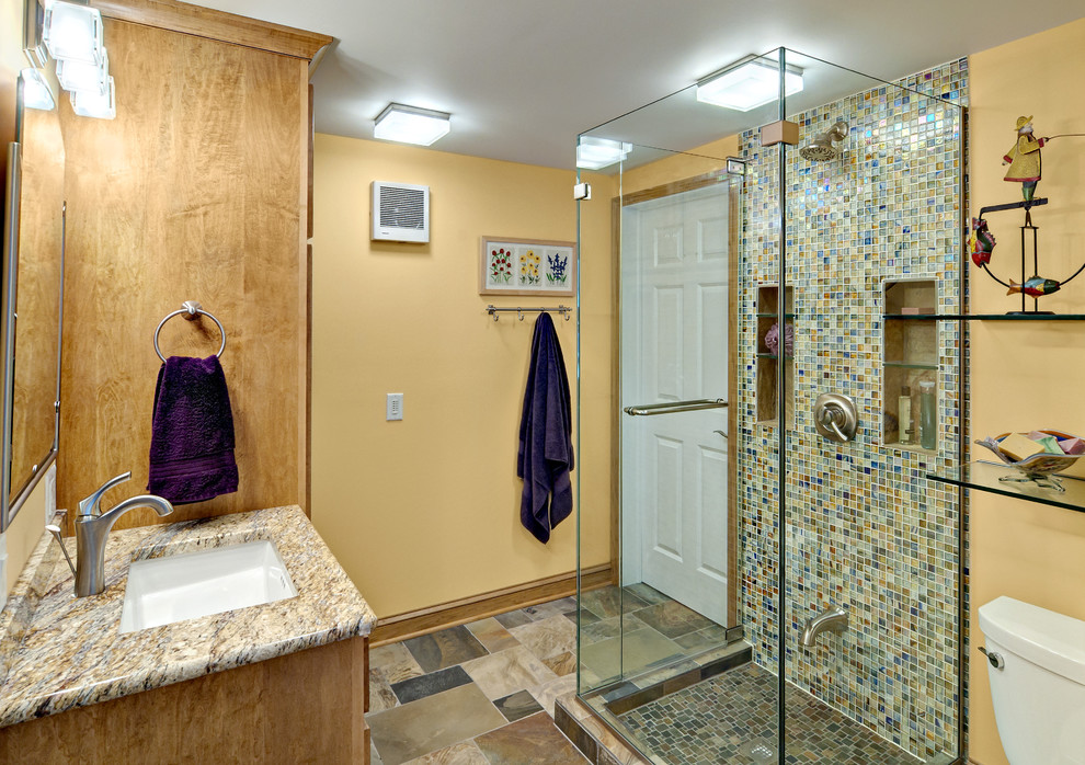 ミネアポリスにある中くらいなコンテンポラリースタイルのおしゃれなバスルーム (浴槽なし) (アンダーカウンター洗面器、シェーカースタイル扉のキャビネット、淡色木目調キャビネット、アルコーブ型シャワー、一体型トイレ	、マルチカラーのタイル、モザイクタイル、黄色い壁、スレートの床、マルチカラーの床、開き戸のシャワー) の写真