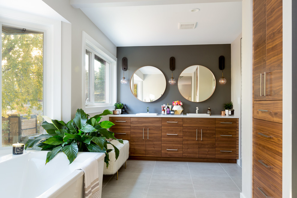 Photo of a retro shower room bathroom in Other with flat-panel cabinets, medium wood cabinets, a freestanding bath, white walls, a built-in sink and grey floors.