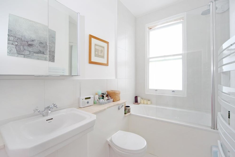 Eklektisk inredning av ett litet badrum, med ett integrerad handfat, bänkskiva i kalksten, ett platsbyggt badkar, en dusch/badkar-kombination, vit kakel, keramikplattor, vita väggar och klinkergolv i keramik