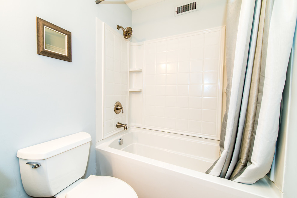 Immagine di una piccola stanza da bagno american style con vasca/doccia, WC a due pezzi, pareti blu e doccia con tenda