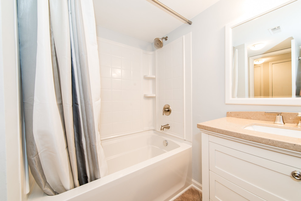 Immagine di una piccola stanza da bagno stile americano con vasca/doccia, pareti blu, lavabo sottopiano e doccia con tenda