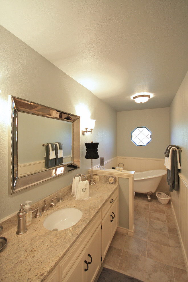 Inspiration för ett mellanstort vintage badrum, med ett undermonterad handfat, luckor med upphöjd panel, vita skåp, ett badkar med tassar, blå väggar och klinkergolv i porslin