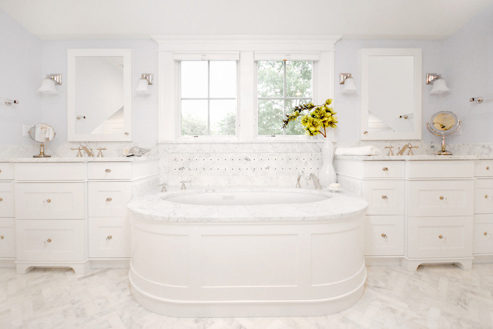 Bathroom - large traditional master white tile and stone tile marble floor bathroom idea in New York with an undermount sink, white cabinets, marble countertops, an undermount tub, shaker cabinets and white walls